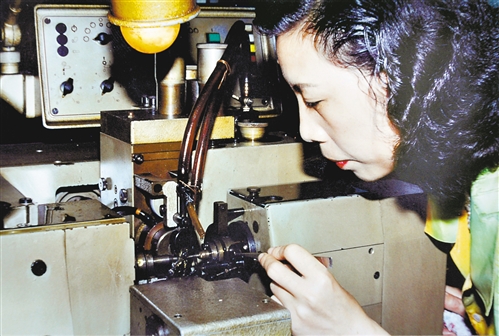1987年,重庆钟表厂手表轮系车间,工人在操作从瑞士进口的滚齿机.
